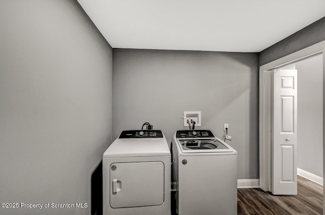 laundry area featuring dark wood-type flooring, laundry area, independent washer and dryer, and baseboards