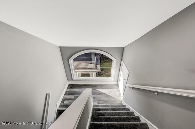 stairway featuring baseboards and wood finished floors