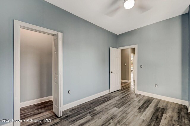 unfurnished bedroom featuring a ceiling fan, baseboards, and wood finished floors