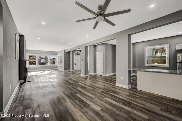 unfurnished living room featuring ceiling fan, baseboards, dark wood-type flooring, and recessed lighting