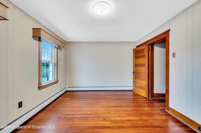 100 Short St, Edwardsville, PA 18704 - empty room with wooden walls, hardwood / wood-style floors, and a baseboard heating unit
