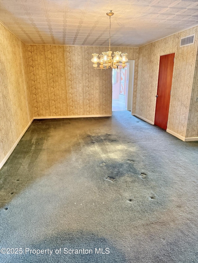 empty room with dark carpet and a notable chandelier