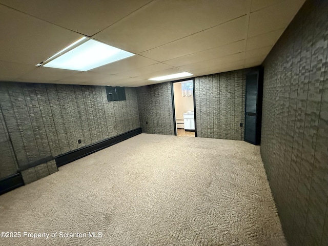 basement featuring electric panel, baseboard heating, and carpet flooring