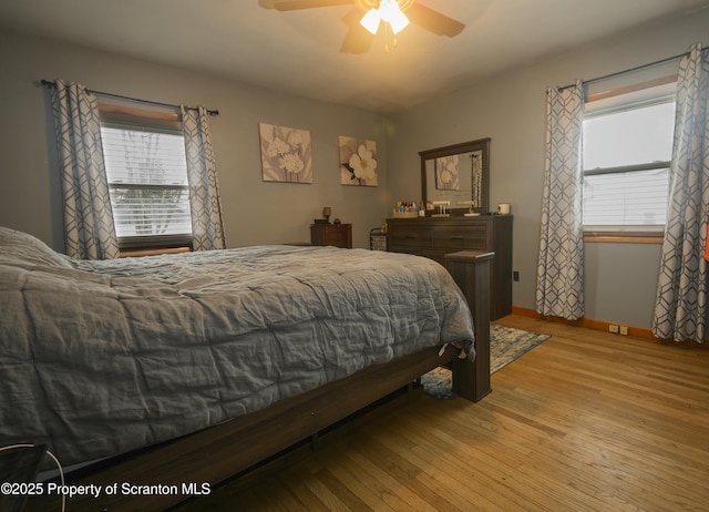 bedroom with a ceiling fan, baseboards, and hardwood / wood-style floors