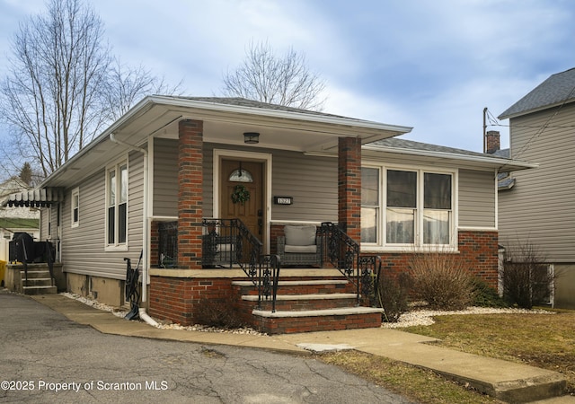 view of front of property featuring brick siding and covered porch