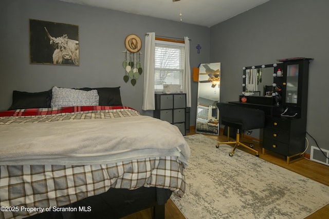 bedroom with visible vents and wood finished floors