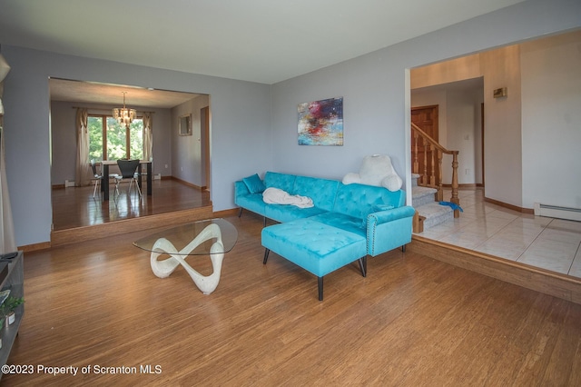 living room featuring a baseboard radiator, a chandelier, and light wood-type flooring