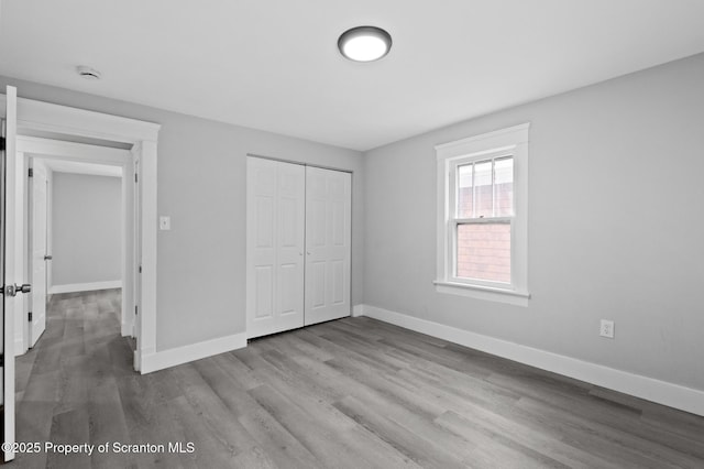 unfurnished bedroom featuring light wood-type flooring and a closet