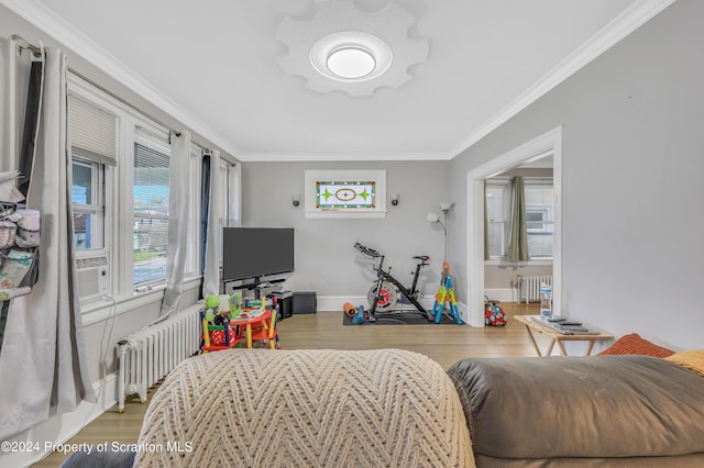 bedroom with wood-type flooring, radiator heating unit, and ornamental molding