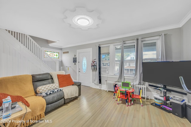 living room featuring radiator, hardwood / wood-style floors, and ornamental molding