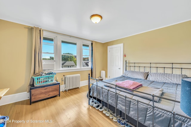 bedroom featuring wood-type flooring and radiator