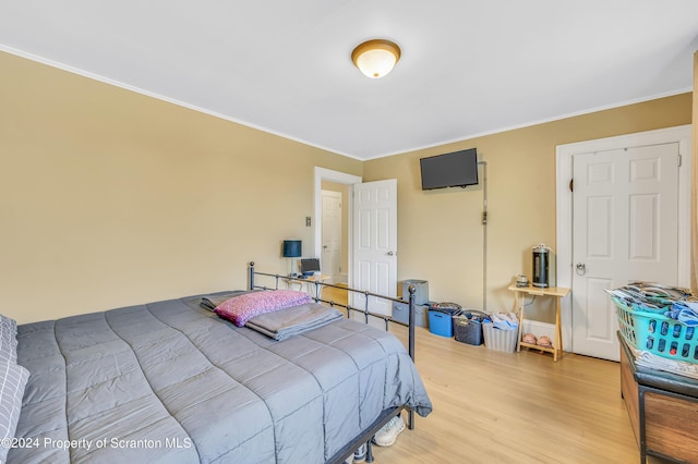 bedroom featuring light wood-type flooring and ornamental molding