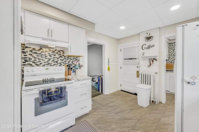 kitchen featuring light stone countertops, white cabinetry, radiator heating unit, a drop ceiling, and white appliances