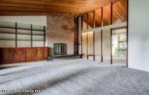 unfurnished living room featuring radiator heating unit and carpet