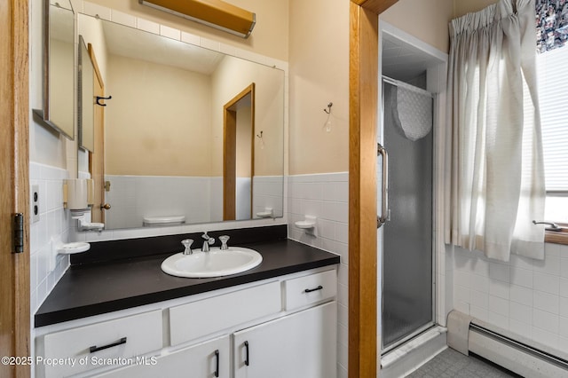 bathroom featuring vanity, baseboard heating, tile walls, and a shower stall