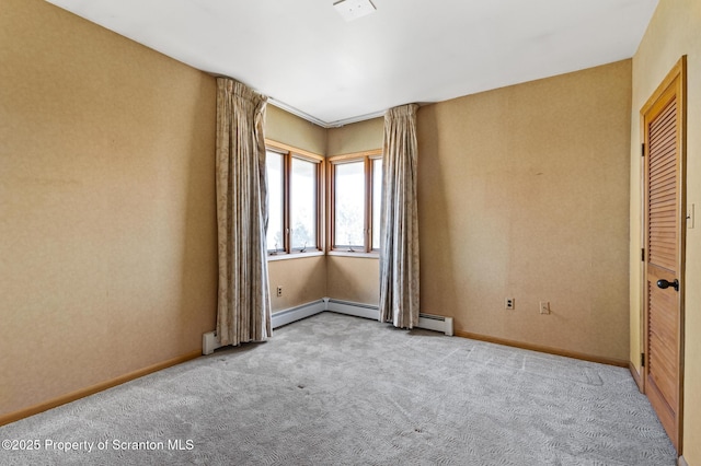 empty room featuring carpet flooring, baseboards, and a baseboard radiator