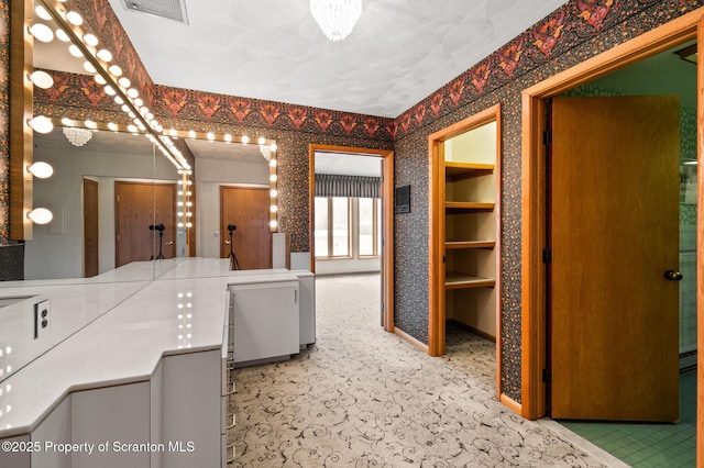 bathroom featuring wallpapered walls and visible vents