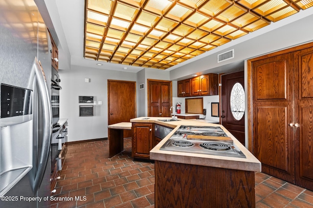 kitchen with baseboards, visible vents, a sink, light countertops, and appliances with stainless steel finishes