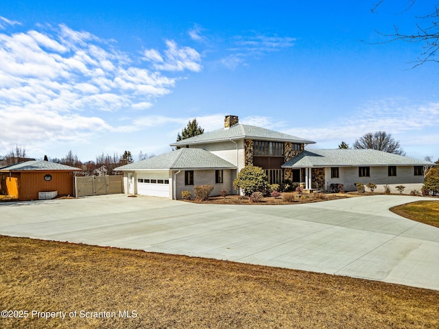 view of front of home featuring a gate, driveway, a chimney, stone siding, and a garage