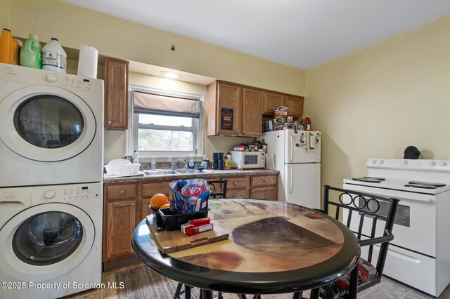 347 Orchard St, Old Forge, PA 18518 - kitchen with a sink, white appliances, stacked washing maching and dryer, and brown cabinets