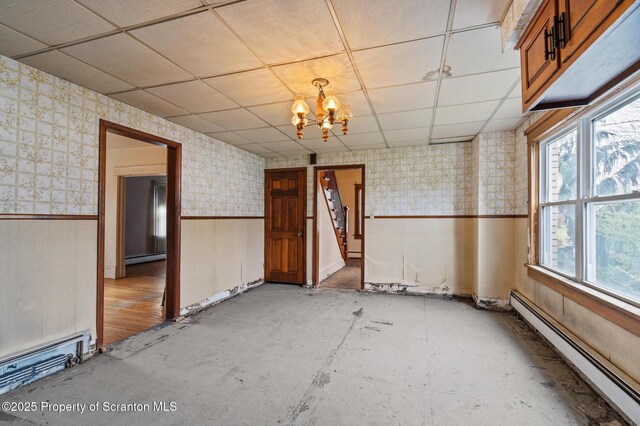 347 Orchard St, Old Forge, PA 18518 - spare room with a notable chandelier, a baseboard heating unit, wallpapered walls, a wainscoted wall, and a drop ceiling