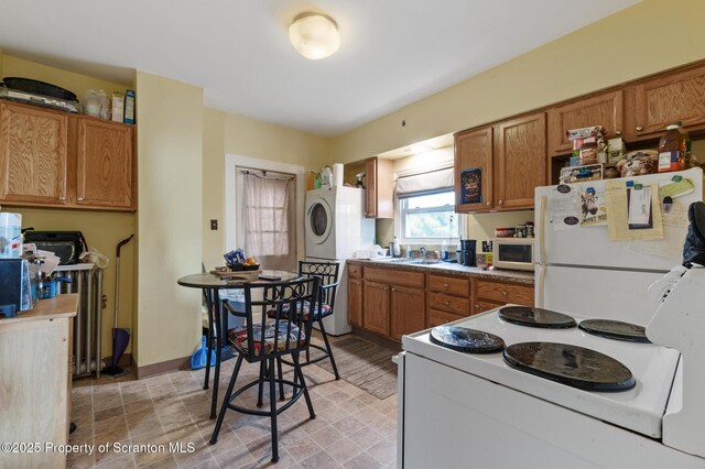 347 Orchard St, Old Forge, PA 18518 - kitchen featuring brown cabinets, white appliances, stacked washer and dryer, and a sink