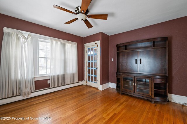 347 Orchard St, Old Forge, PA 18518 - unfurnished living room with a baseboard radiator, a ceiling fan, wood finished floors, and baseboards