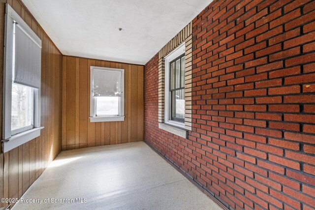 347 Orchard St, Old Forge, PA 18518 - interior space featuring brick wall, wooden walls, and a healthy amount of sunlight