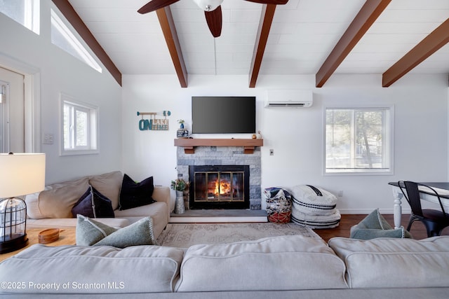 living room featuring light hardwood / wood-style flooring, ceiling fan, vaulted ceiling with beams, a wall unit AC, and a fireplace