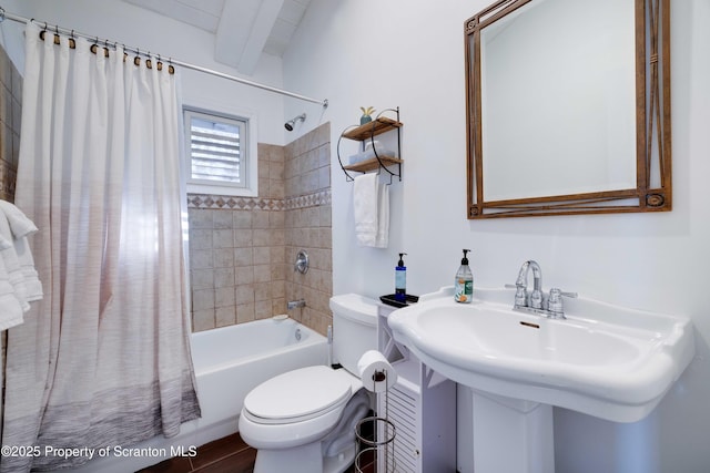 full bathroom featuring shower / bath combination with curtain, toilet, and sink