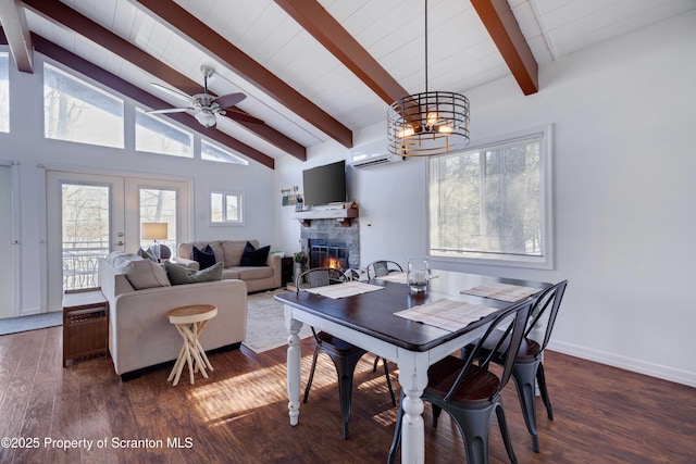 dining area with a stone fireplace, dark hardwood / wood-style floors, a wall mounted air conditioner, vaulted ceiling with beams, and french doors