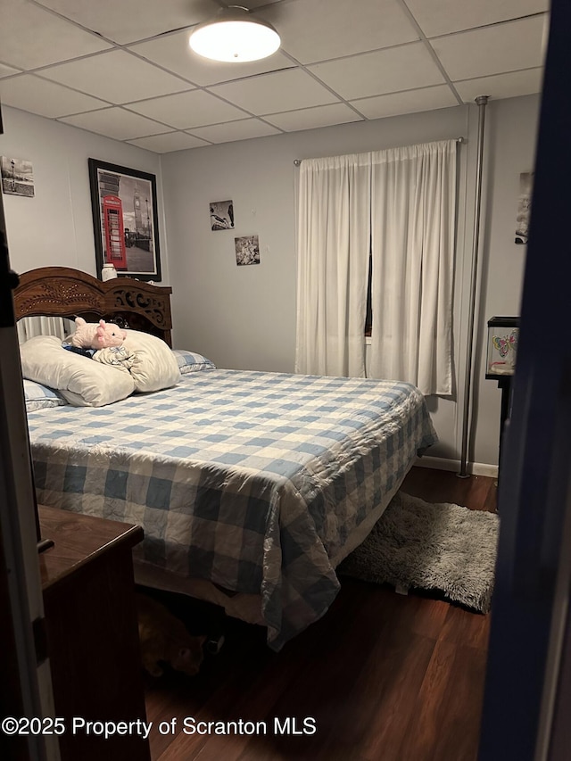 bedroom featuring a drop ceiling and hardwood / wood-style floors