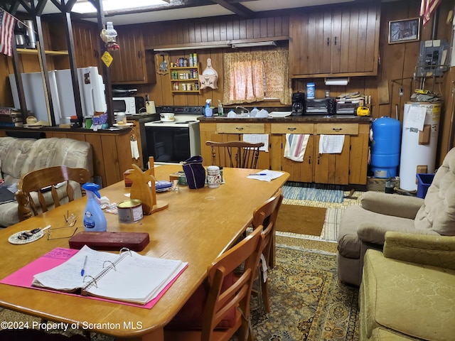 kitchen featuring wooden walls, gas water heater, and white appliances