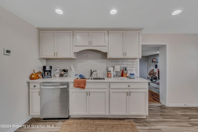 kitchen with dishwasher, backsplash, white cabinets, and sink