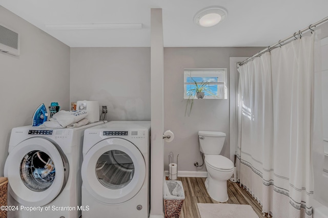 washroom with light hardwood / wood-style flooring and washing machine and clothes dryer