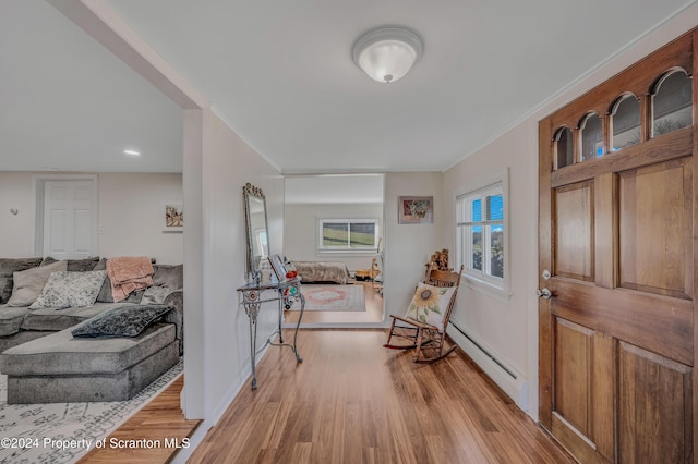 foyer with baseboard heating and light hardwood / wood-style floors