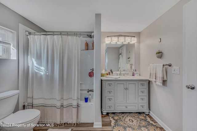 full bathroom with hardwood / wood-style flooring, vanity, toilet, and shower / bath combo with shower curtain