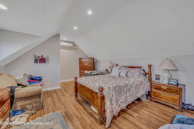 bedroom with vaulted ceiling and light hardwood / wood-style flooring