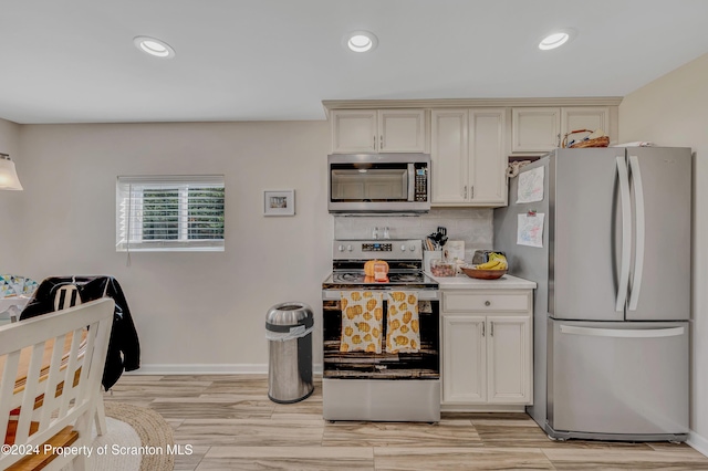 kitchen featuring decorative backsplash, light hardwood / wood-style floors, and appliances with stainless steel finishes