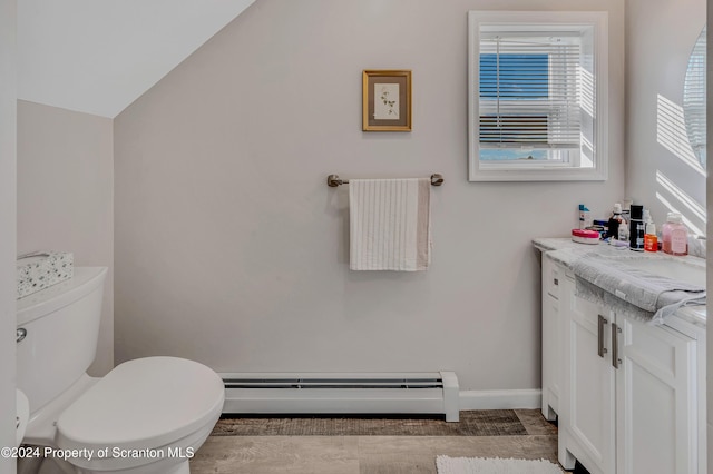 bathroom with vanity, vaulted ceiling, toilet, baseboard heating, and wood-type flooring