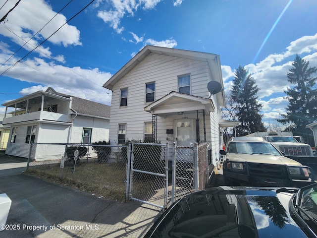 view of front of house featuring a fenced front yard, an attached carport, and a gate