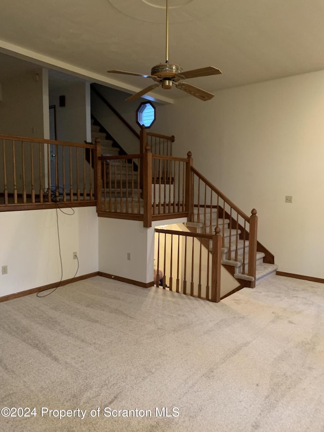 unfurnished living room featuring carpet flooring and ceiling fan