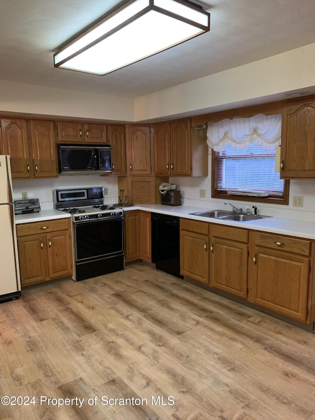 kitchen featuring light wood-type flooring, sink, and black appliances