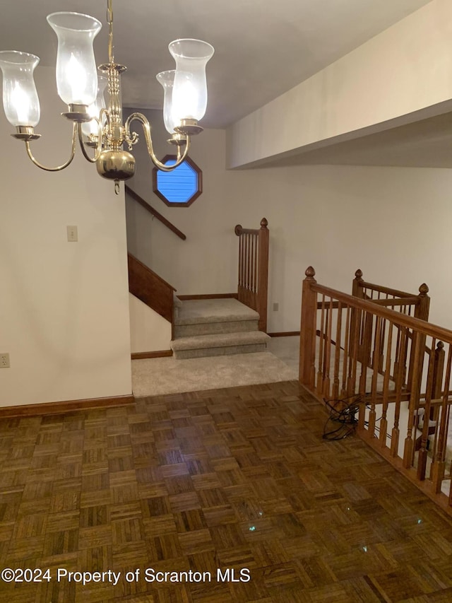 interior space featuring dark parquet flooring and a chandelier