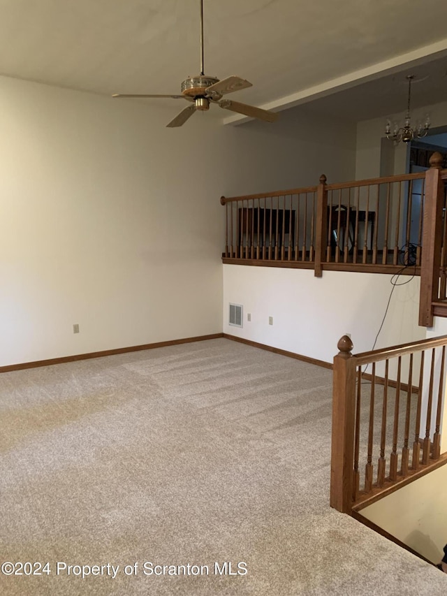 unfurnished living room featuring carpet flooring and ceiling fan with notable chandelier