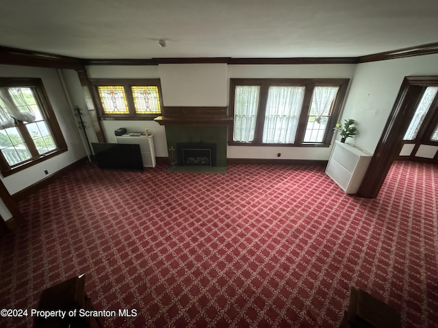 unfurnished living room featuring carpet flooring and crown molding