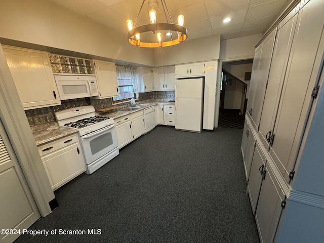 kitchen with decorative backsplash, white appliances, sink, pendant lighting, and white cabinetry