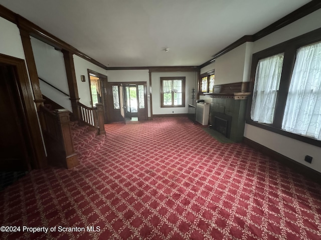 unfurnished living room featuring carpet floors and ornamental molding