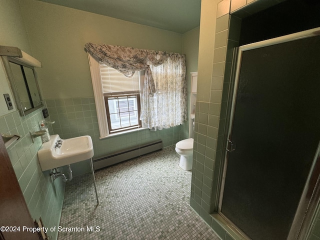 bathroom featuring tile patterned floors, a shower with door, tile walls, and a baseboard radiator