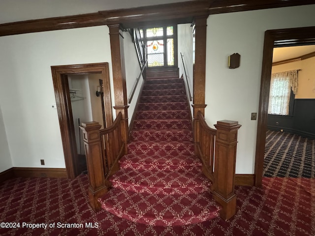 staircase featuring carpet floors, plenty of natural light, and ornamental molding